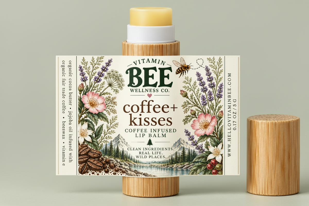 A lip balm stick with its illustrated cardboard sleeve standing upright, alongside a second cap placed to the right, on a light gray background. The sleeve reads 'Vitamin Bee Wellness Co.
